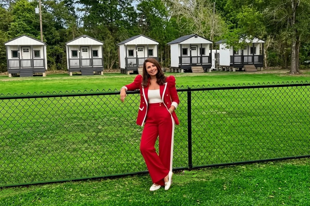 Lu-Ann, founder of Uppity Pet Salon & Resort, in front of the private boarding cabins